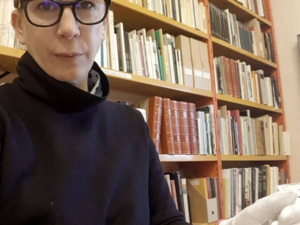 Christina Zetterlund sitter med arkivhandlingar ur Rosa Taikons arkiv i museets bibliotek