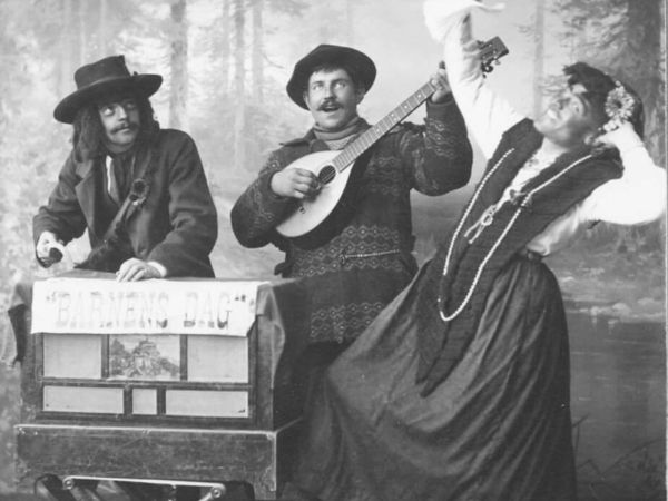 Ett musikuppträdande vid Barnens dag med tre utklädda personer.